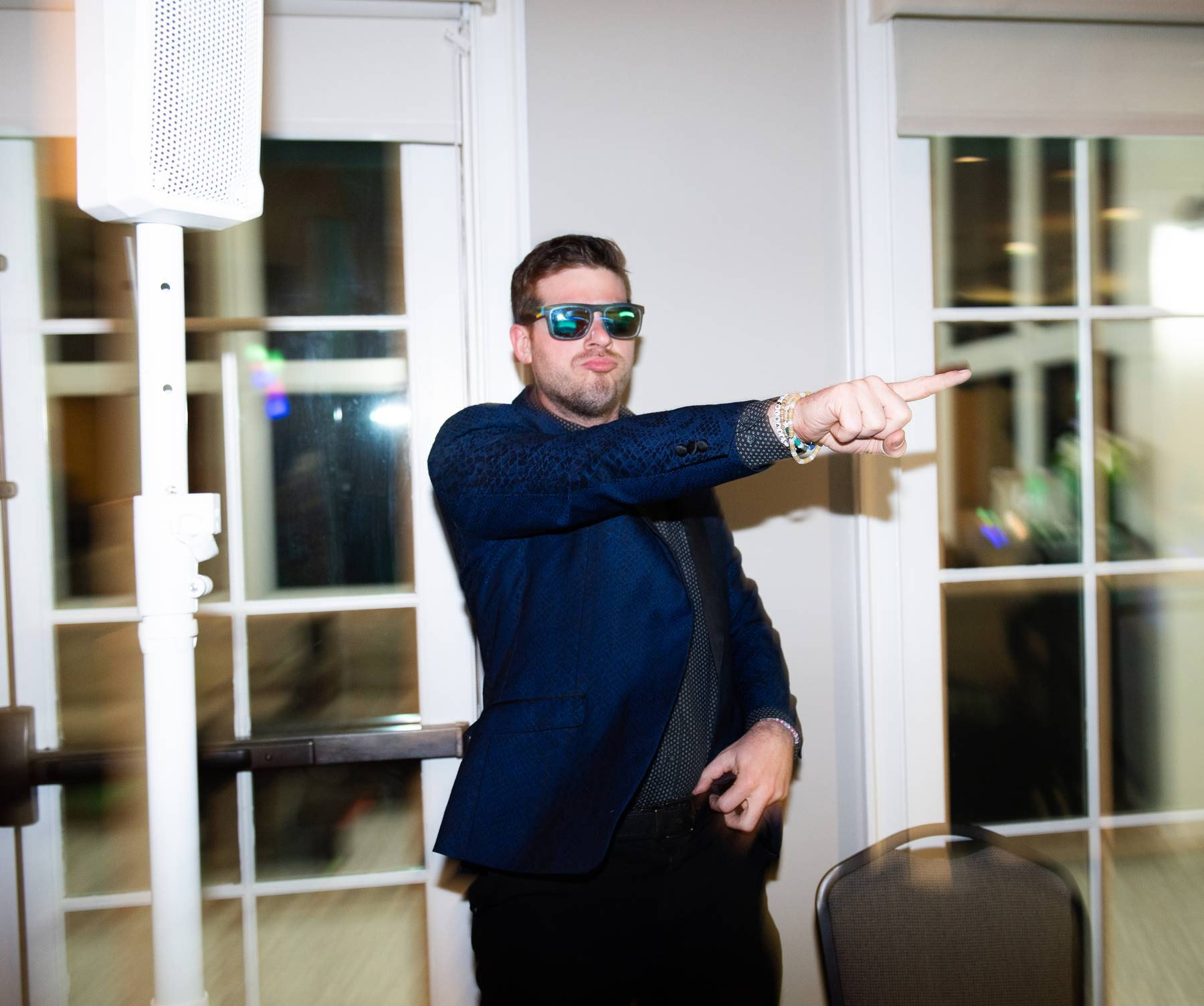 Benji pointing toward the dance floor wearing sunglasses