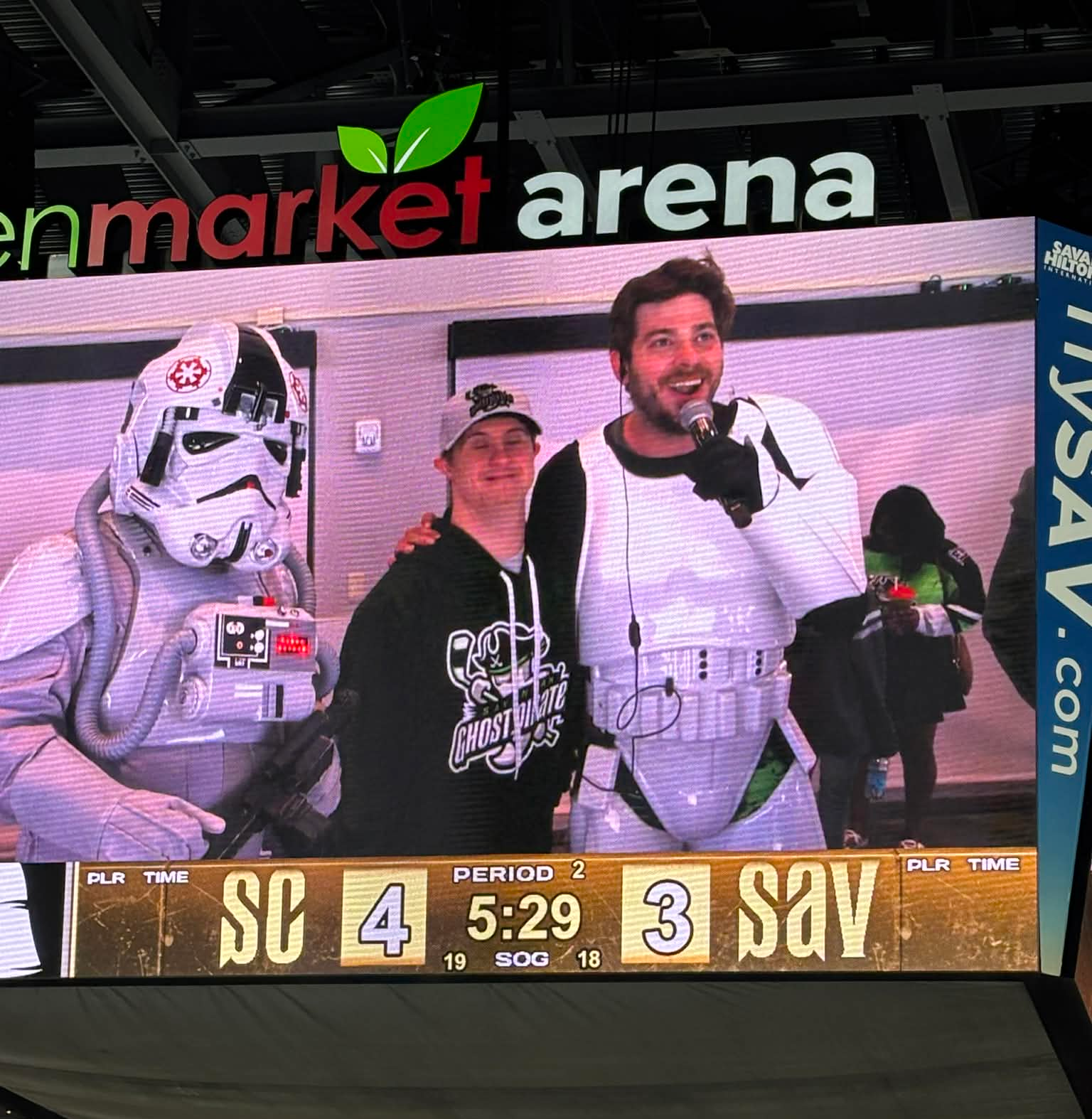 Benji on the ice with mic near the boards during a pro game
